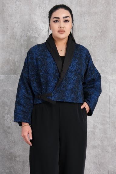  This image shows a model wearing a womens jacket in cobalt blue. The jacket is crafted from a blend of 65% Viscose and 35% Polyester, offering extra comfort and elegance. It is available in sizes S, M, and L. With button details on the front and an eye-catching fabric pattern, it provides a modern and striking look. Its stylish and comfortable cut makes this jacket a perfect choice for both daily wear and special occasions, becoming an indispensable piece of your wardrobe.