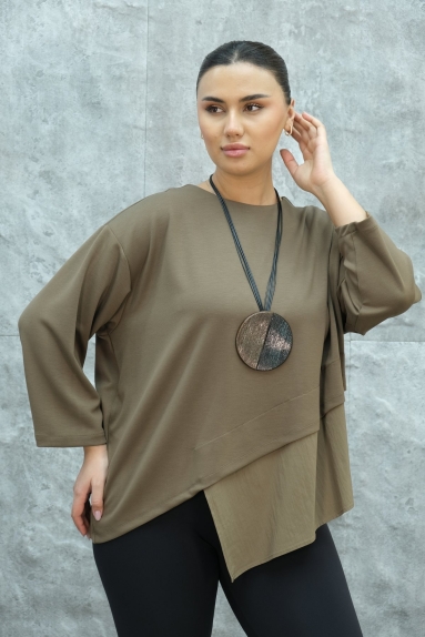  This elegant womens blouse stands out with its modern design and high-quality fabric. The blouse is beige in color and available in sizes L and XL. The fabric composition includes 80% Viscose, 15% Polyester, and 5% Elastane. With its asymmetrical cuts on the front and back, it is a perfect choice for fashion-forward women. The drapery and comfortable fit of the blouse make it ideal for both daily wear and special occasions. The combination on the model proves how chic and versatile the blouse can be.