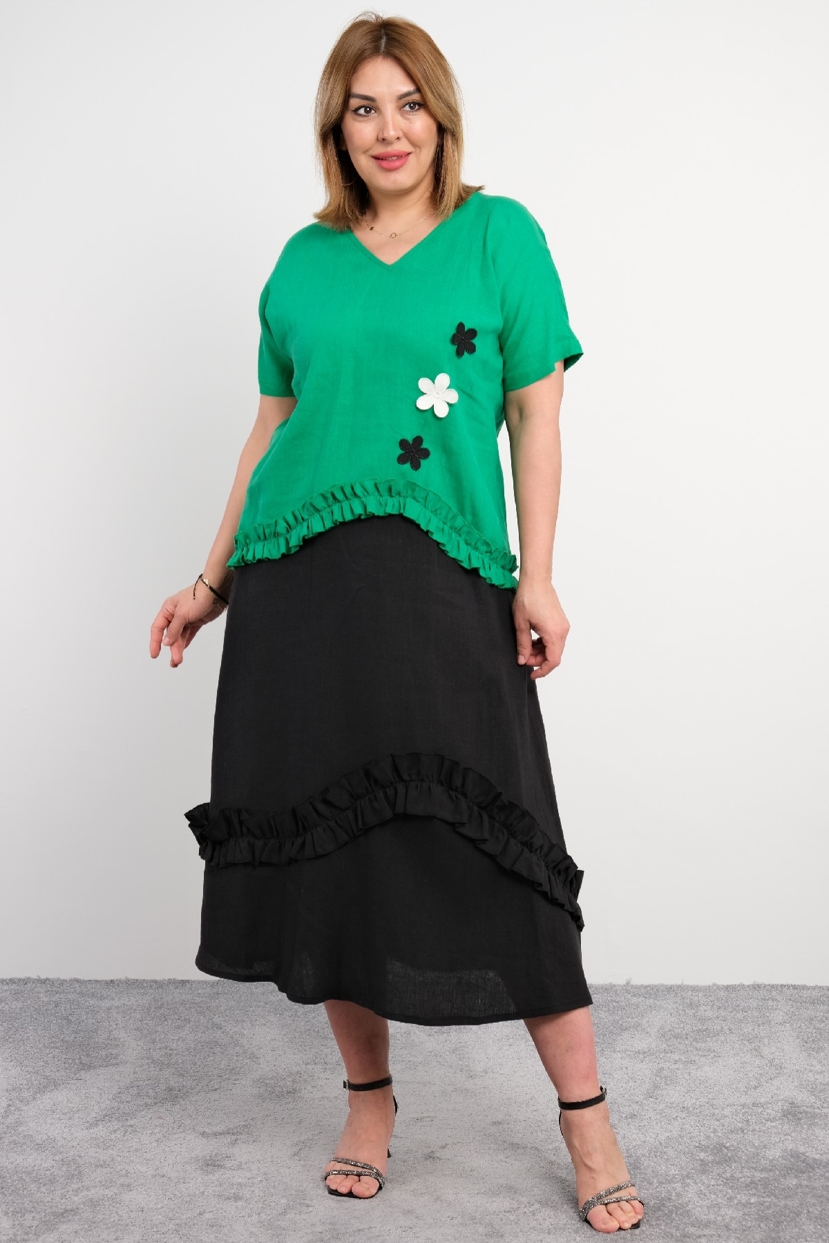  Two-piece suit for plus size women with ruffle details on the bottom, flower motifs, short sleeves, green color.