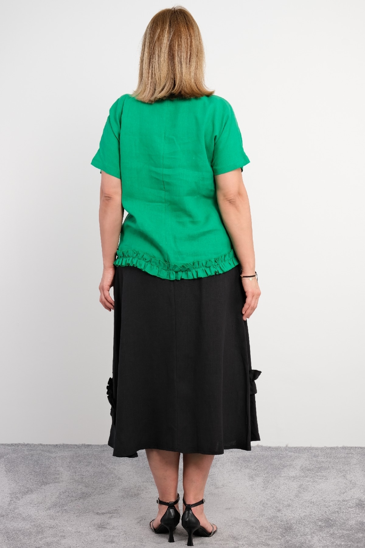  Two-piece suit for plus size women with ruffle details on the bottom, flower motifs, short sleeves, green color.
