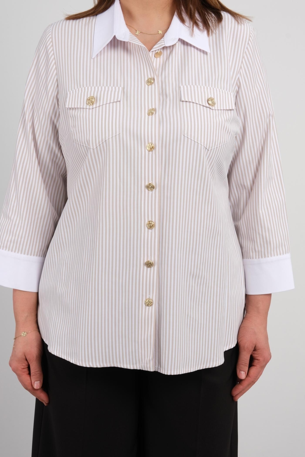  This plus-size womens shirt comes in beige and offers four different size options: 44, 46, 48, and 50. The fabric composition is 65% cotton, 30% polyester, and 5% elastane, providing a comfortable and stretchy wearing experience. The front features elegant button closures and has two chest pocket details. The contrasting white cuffs and collar add a modern touch.