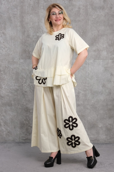  Этот комплект для женщин плюс сайз является отличным выбором, который сочетает в себе комфорт и элегантность. Костюм жёлтого цвета доступен в размерах 50, 52, 54 и 56. Верх состоит из рубашки с короткими рукавами и круглым вырезом, украшенной черной вышивкой в виде цветов на передней части. Воланы на талии добавляют динамичности. Нижняя часть — это широкие брюки, украшенные чёрными цветочными узорами, которые завершают образ. Состав ткани: 65% хлопок, 30% полиэстер и 5% эластан, что обеспечивает мягкость и эластичность. Этот комплект идеально подходит как для повседневной носки, так и для особых случаев.