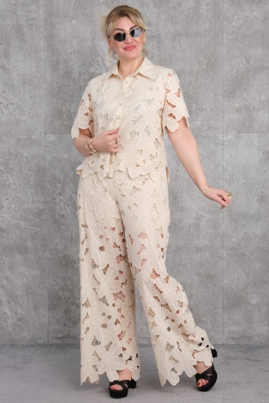  هذا الطقم المكون من قطعتين للنساء بالحجم الكبير يعدّ إضافة أنيقة لخزانة ملابسك. يتميز هذا الطقم باللون البيج، ومصنوع من 65% قطن، 30% بوليستر و 5% إلاستان، مما يوفر ارتداءً مريحًا ومرنًا. يتميز المنتج الذي يظهر على العارضة بنقوش الزهور البيضاء من الأمام والخلف، مما يدمج الأساليب الكلاسيكية والمعاصرة معًا. الأحجام المتاحة هي 42، 44، 46 و48. الجزء العلوي ذو أكمام قصيرة وزرار، بينما الجزء السفلي مصمم بأرجل واسعة. هذا الطقم، الذي يمكن للنساء بالحجم الكبير اختياره بسهولة، يبرز بتصميمه الأنيق وهيكله المريح.