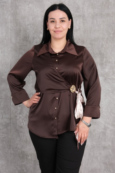  This item is a plus-size brown blouse designed for women. The blouse seen on the model is made of 100% polyester fabric, offering a comfortable and chic look. It features button details and a stylish belt detail on the side. Available in sizes 42, 44, 46, and 48. The blouse closes with buttons at the front, making it perfect for those who appreciate elegant attire.