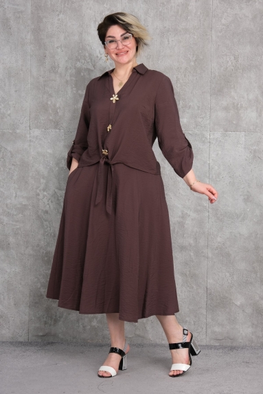  This plus-size womens two-piece suit is a perfect choice for women of all ages, offering comfort and style. The suit comes in brown, making it suitable for both daily wear and special occasions. The top features long sleeves, button details, and a tie-front design that adds dynamism. The bottom part has a wide and comfortable cut. Available in sizes 42, 44, 46, and 48, it caters to various body sizes. The fabric composition is 65% cotton, 30% polyester, and 5% elastane, providing a comfortable wearing experience and ensuring durability.