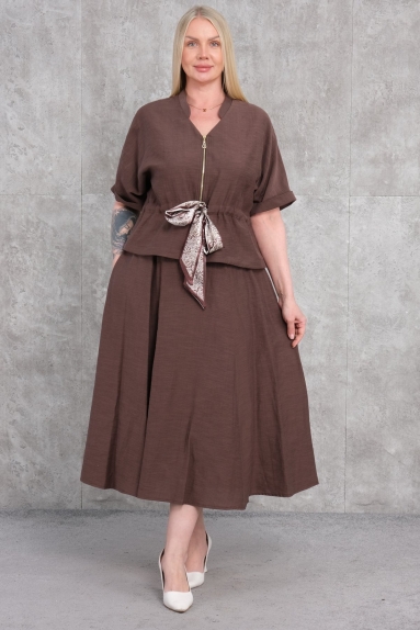  This elegant plus-size womens dress in brown offers a comfortable and stylish look. The dress, seen on the model, is available in sizes 42, 44, 46, and 48, ensuring a perfect fit for different body types due to its stretchy fabric content. The fabric consists of 65% cotton, 30% polyester, and 5% elastane, making it both durable and comfortable. The zipper detail at the front and the fabric belt at the waist add modern touches to the elegance. Its short-sleeve and V-neck design make it perfect for everyday wear. 