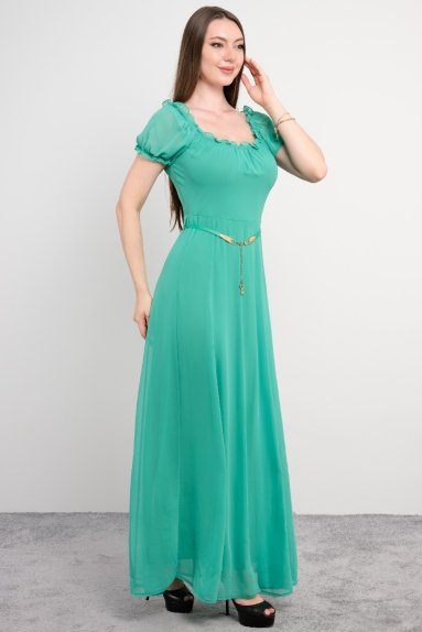  This dress is a small size women's garment displayed on a model, belonging to the STELLA brand, and is green in color. The dress has a chiffon-like appearance and is made of 100% polyester fabric. Available sizes are 36, 38, 40, and 42. The dress features feminine details on the front, has short sleeves, and is complemented with an elegant belt at the waist. The back has a delicate tying detail and button closure.