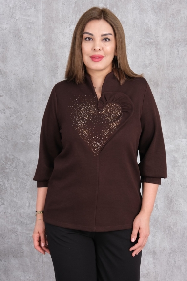  This plus-size womens blouse stands out with its brown color. The front part of the blouse features an impressive detail with gold-colored decorations in the shape of a heart. This 3/4 sleeve blouse offers both elegance and comfort. Available sizes are 42, 44, 46, and 48. The fabric content consists of 75% Polyester, 20% Cotton, and 5% Lycra. This combination ensures the blouse is both comfortable and flexible.