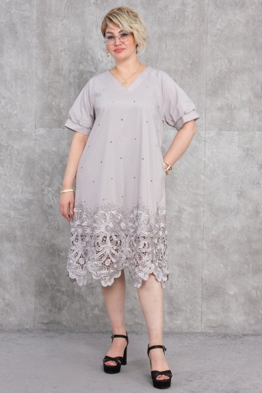  This plus-size womens casual dress combines elegance and comfort with its grey color. It is designed with a lightweight and breathable fabric, making it ideal for summer use. The fabric composition is 75% cotton, 20% polyester, and 5% lycra. This mix makes the dress comfortable, stretchy, and durable. The dress features a V-neck design, elegant short sleeves, and lace details at the hem, adding a touch of sophistication. The available sizes are 42, 44, 46, and 48.
