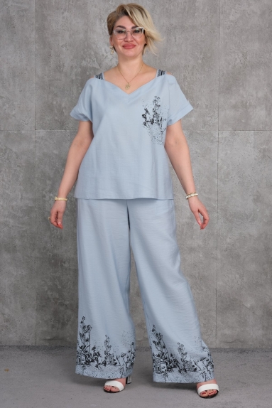  This product is a plus-size womens two-piece set in gray, as seen on the model. The available sizes are 42, 44, 46, and 48. The fabric content is 100% cotton, making it extremely soft and comfortable. The top is short-sleeved with an elegant print detail on the chest area. The bottom part is wide-leg pants with print details at the hem. This set offers both comfort and elegance together.