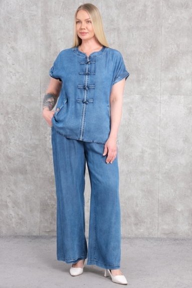  Mankenin üzerinde gördüğünüz bu ürün, büyük beden kadınlar için tasarlanmış mavi renkte spor ikili takımdır. Üst kısmı, rahat ve şık bir görünüm sunar. Kısa kollu tasarımı ve ön tarafta kullanılan düğme detaylarıyla dikkat çeker. Alt kısmı ise geniş paçalı bir pantolon olarak dizayn edilmiştir. Ürünün kumaş içeriği %100 pamuktur, bu da kullanıcıya yüksek konfor ve nefes alabilirlik sağlar. Beden seçenekleri 42, 44, 46 ve 48 olarak sunulmaktadır.