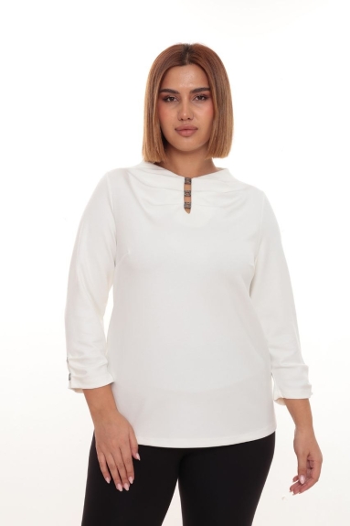  This plus-size womens blouse worn by the model is in an elegant ecru color and made of high-quality fabric. The available sizes for this chic blouse are 42, 44, 46, and 48. The fabric composition is 47% Viscose, 47% Polyester, and 6% Lycra. The front of the blouse has a striking detail, and the sleeves are adorned with elegant buckles. It offers a soft feel for comfortable wear and is an ideal piece for various outfits.